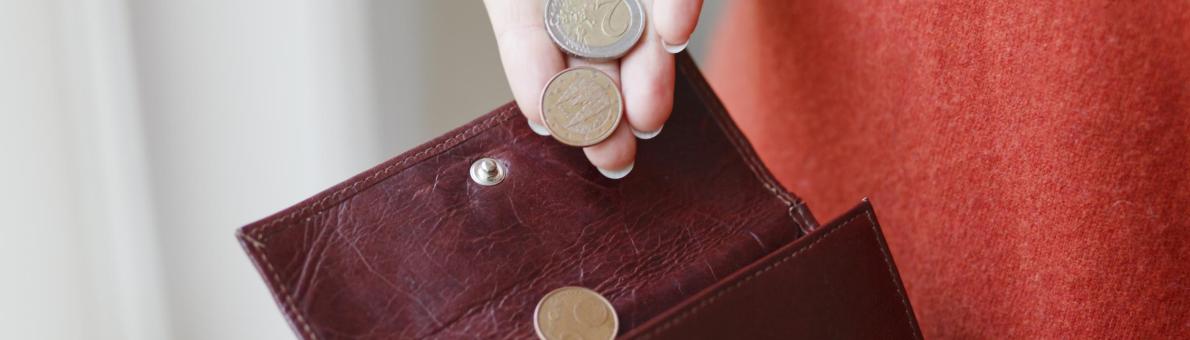 Portemonnee waar muntjes in worden gedaan door een vrouwelijke hand