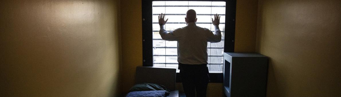 Man in gevangenis staat voor het raam