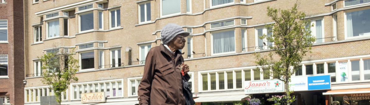 oudere dame met boodschappenkar loopt over straat