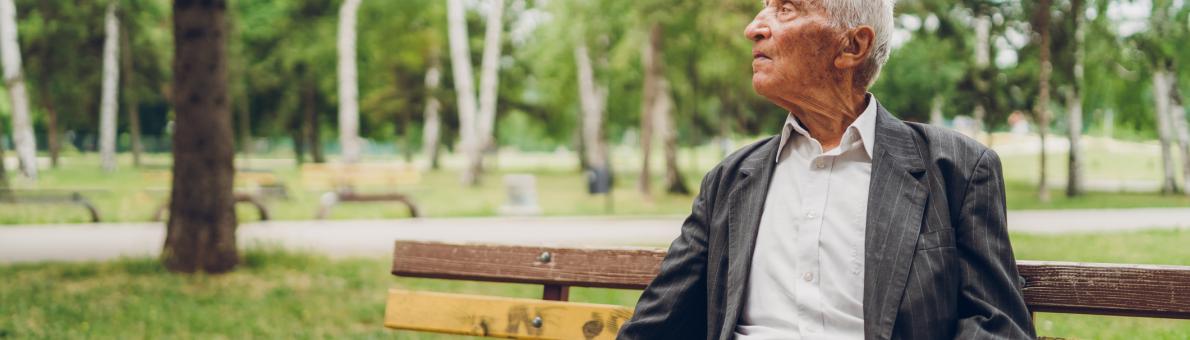 Foto van een senior man op een bankje in het park