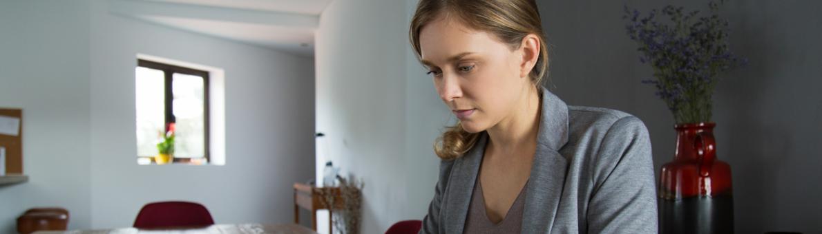 Jonge vrouw met mobiel aan de tafel