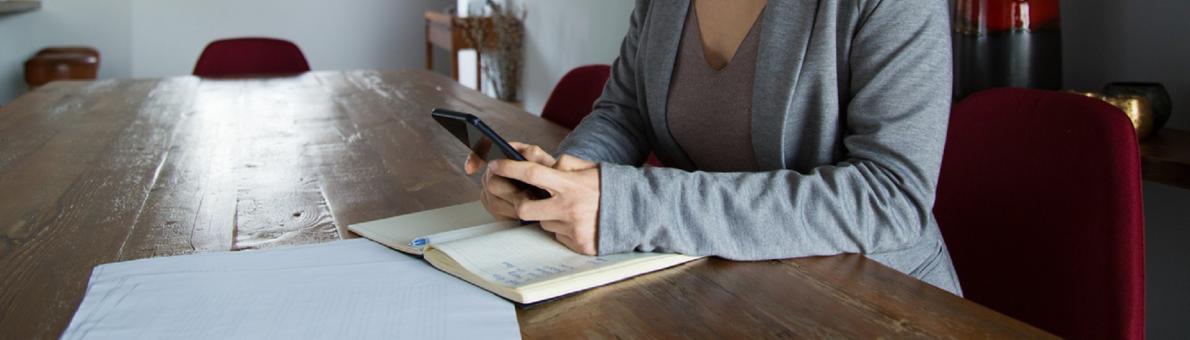 Vrouw aan tafel met mobiel