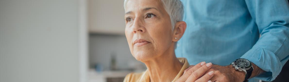 Man legt hand op schouder van zijn vrouw