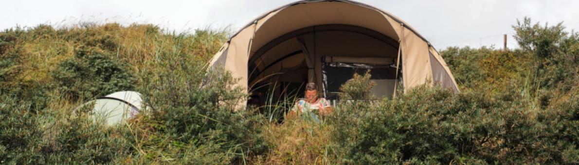 Vrouw kampeert in de duinen