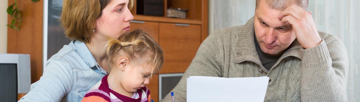 man leest brief aan tafel met vrouw en kind