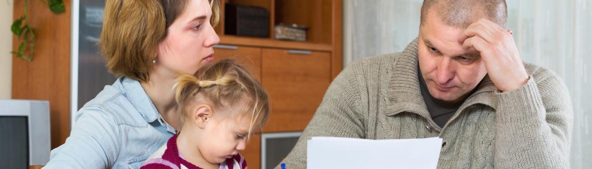 man leest brief aan tafel met vrouw en kind