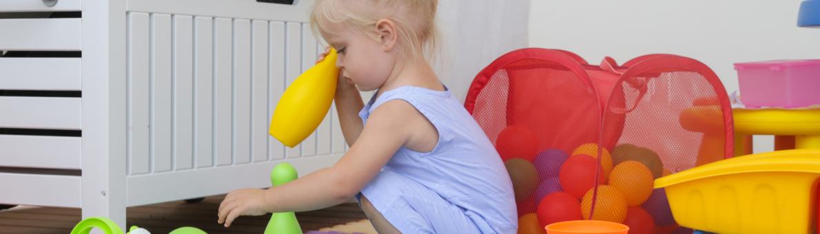 Klein meisje speelt met speelgoed