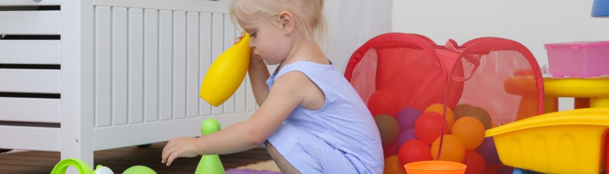 Klein meisje speelt met speelgoed