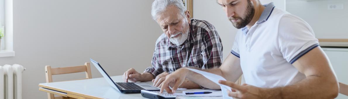 Twee mannen aan tafel bezig met de financiën Twee mannen aan tafel bezig met de financiën