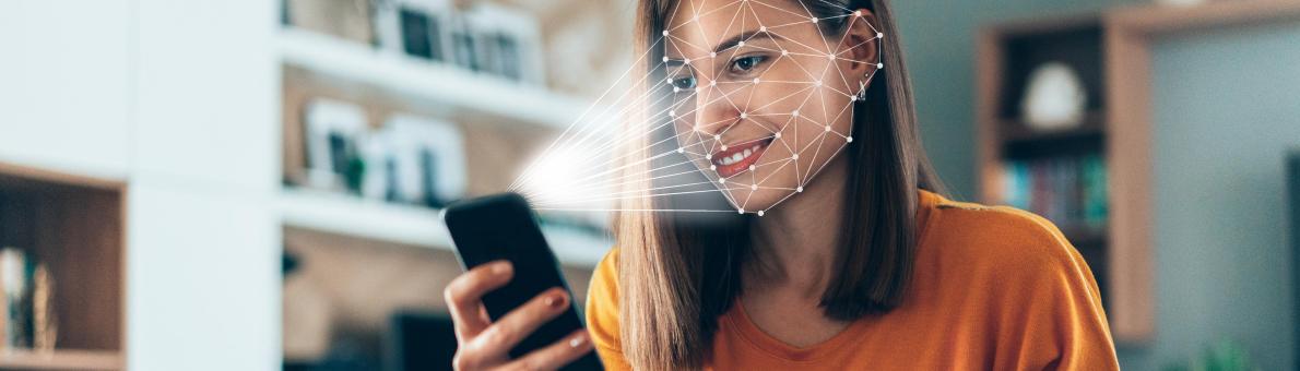 Vrouw houdt smartphone vast en maakt gebruikt van biometrische gezichtsherkenning Vrouw houdt smartphone vast en maakt gebruikt van biometrische gezichtsherkenning