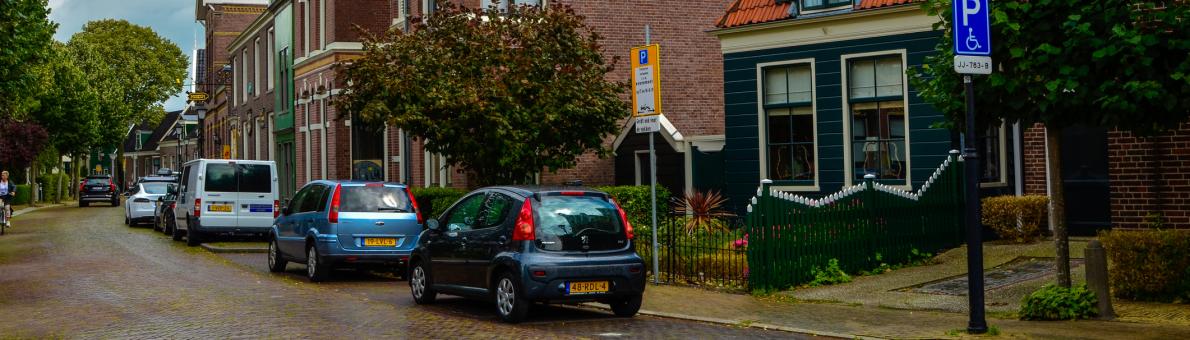 Een straat in Nederland met geparkeerde auto's