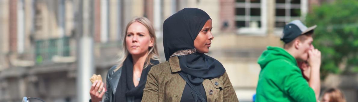 Zwarte vrouw met hoofddoek in een drukke straat