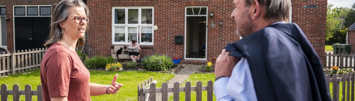 Nationale ombudsman Reinier van Zutphen spreekt met vrouw in Groningen voor haar huis over schade gaswinning