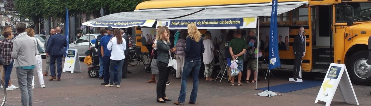 Foto van de gele Ombudsbus op de markt in de provincie Drenthe