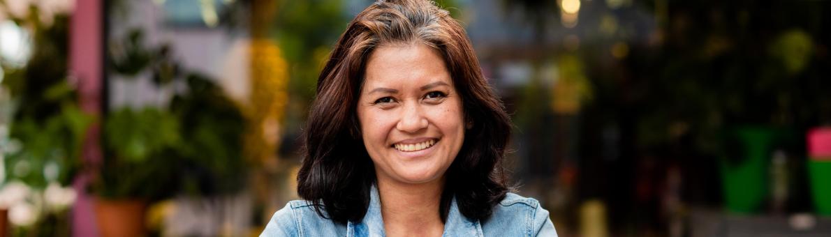 Cora, een vrouw van middelbare leeftijd met bruin haar en een spijkerjasje aan. Ze leunt op een kinderwagen. Cora, een vrouw van middelbare leeftijd met bruin haar en een spijkerjasje aan. Ze leunt op een kinderwagen.