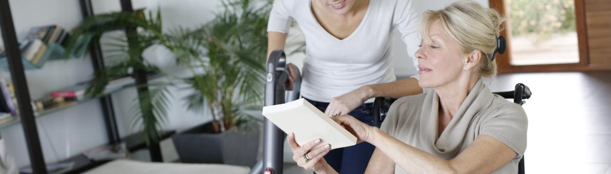 thuiszorg, vrouw zit in rolstoel en is in gesprek met hulp