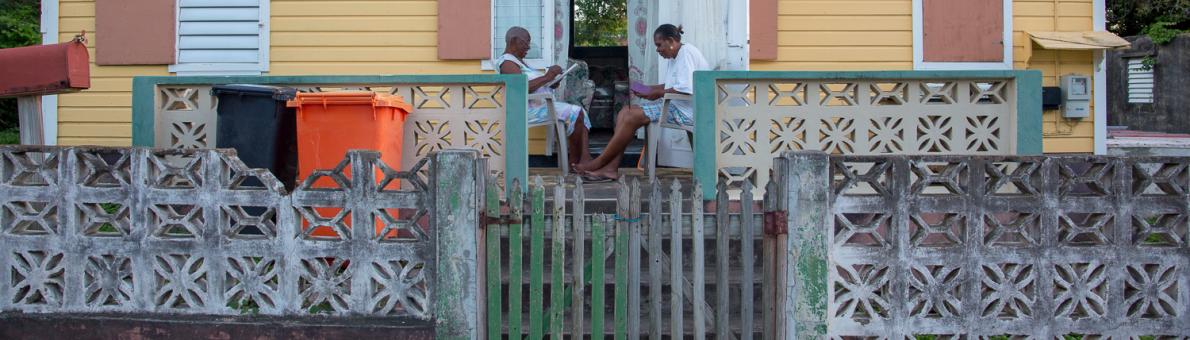 Twee mensen zitten voor hun huis op Statia Twee mensen zitten voor hun huis op Statia