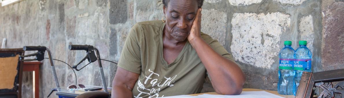 Caribische vrouw zit aan tafel en leest document