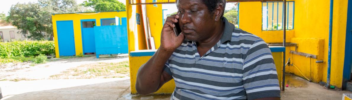 Man in Caribisch Nederland aan de telefoon