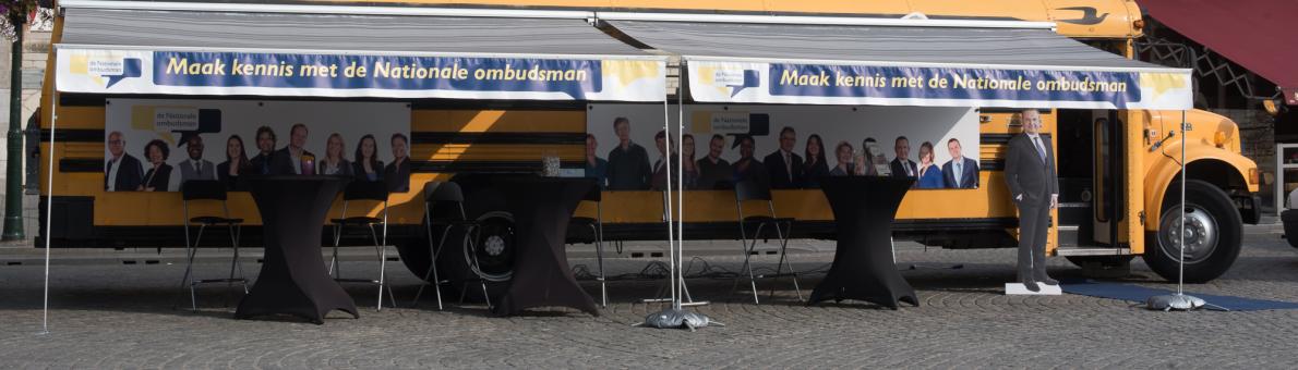 Gele geparkeerde Ombudsbus van de Nationale ombudsman