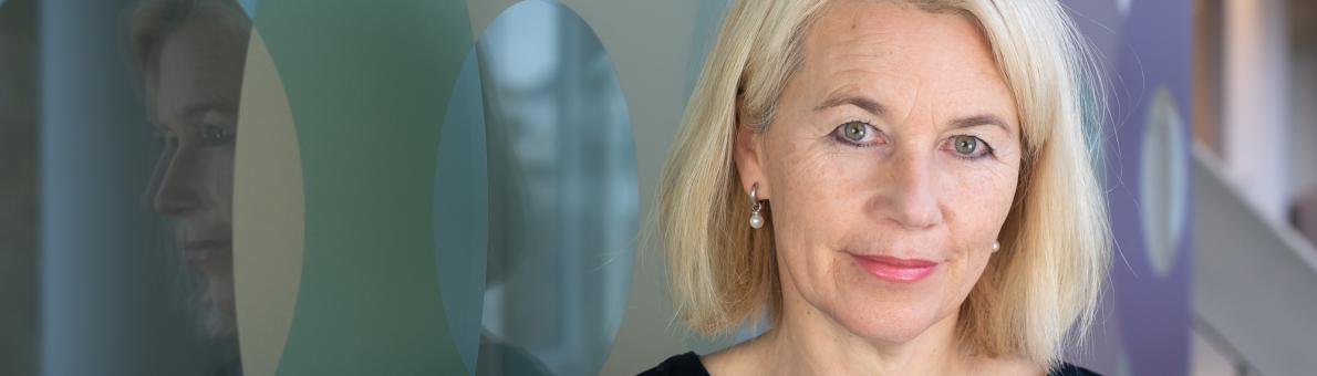 Vrouw met halflang blond haar (Annemarie Tuzgöl, Nationale ombudsman). Ze draagt een blauwe blouse