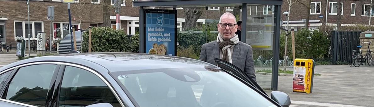 Taxichauffeur Dick Bakker naast zijn taxi