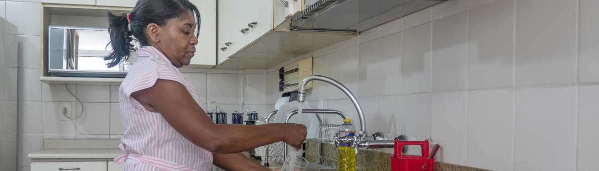 Woman uses tap water in kitchen