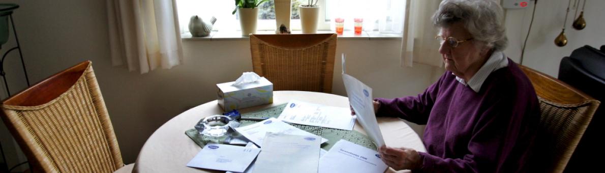 Foto van een vrouw aan tafel met papieren