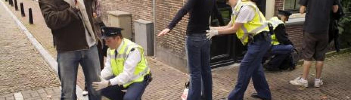 Foto van twee mensen die gefouilleerd worden door de politie