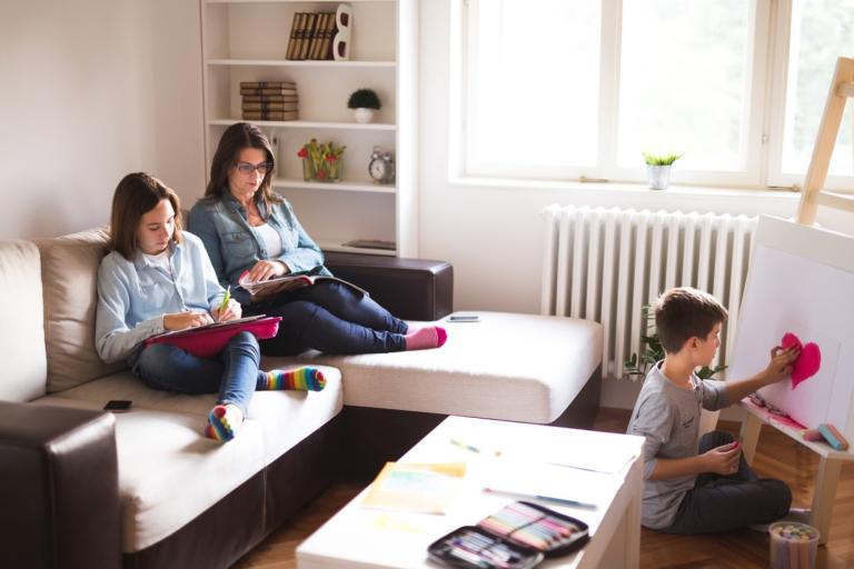 Moeder zit met kinderen op de bank