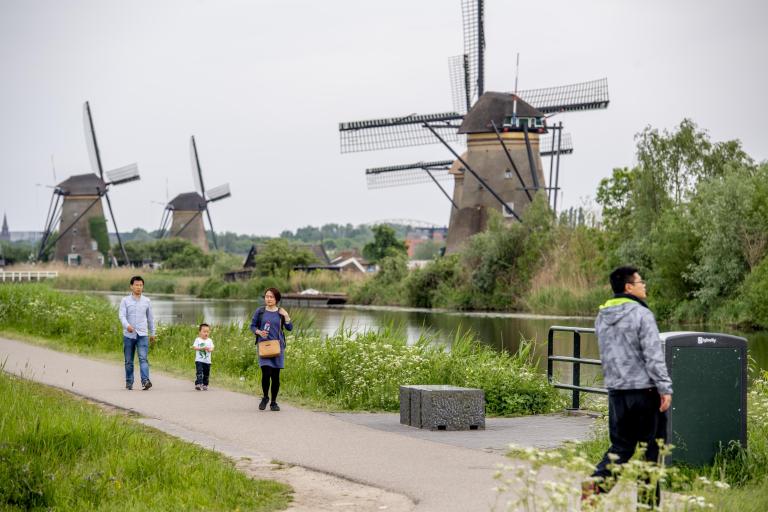 Toeristen bekijken molens op Kinderdijk
