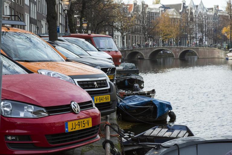 Auto's staan in een parkeervak bij de Amsterdamse grachten