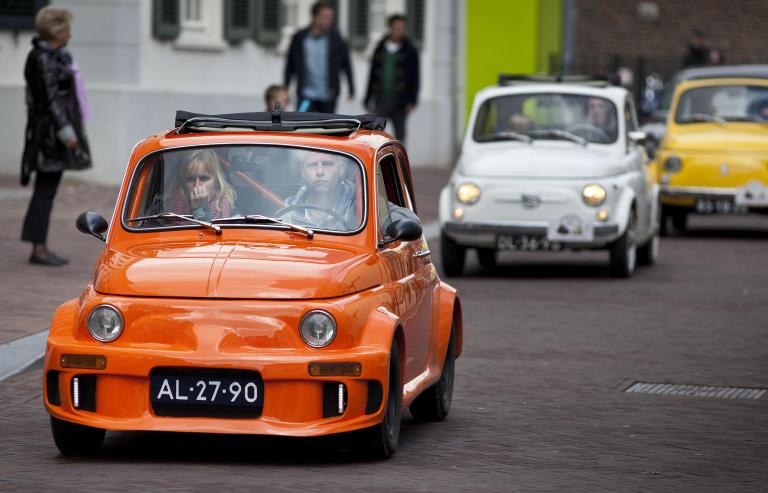 Man en vrouw rijden in een Fiat500