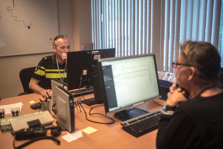 Politieagent achter computer Politieagent achter computer