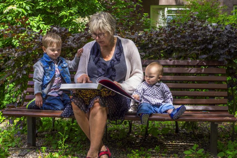 Vrouw op leeftijd met twee kinderen in de tuin